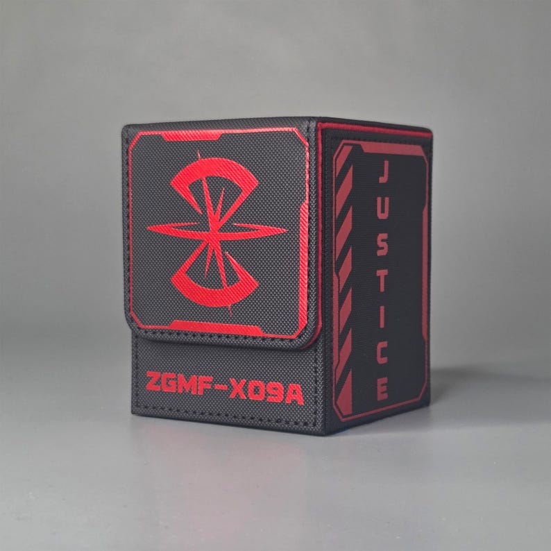 Black and red trading card deck box with magnetic lid, textured exterior and bold justice themed design, premium tabletop card storage case