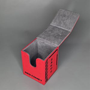 Open red TCG deck box showing soft interior lining and card storage compartment for standard size trading cards