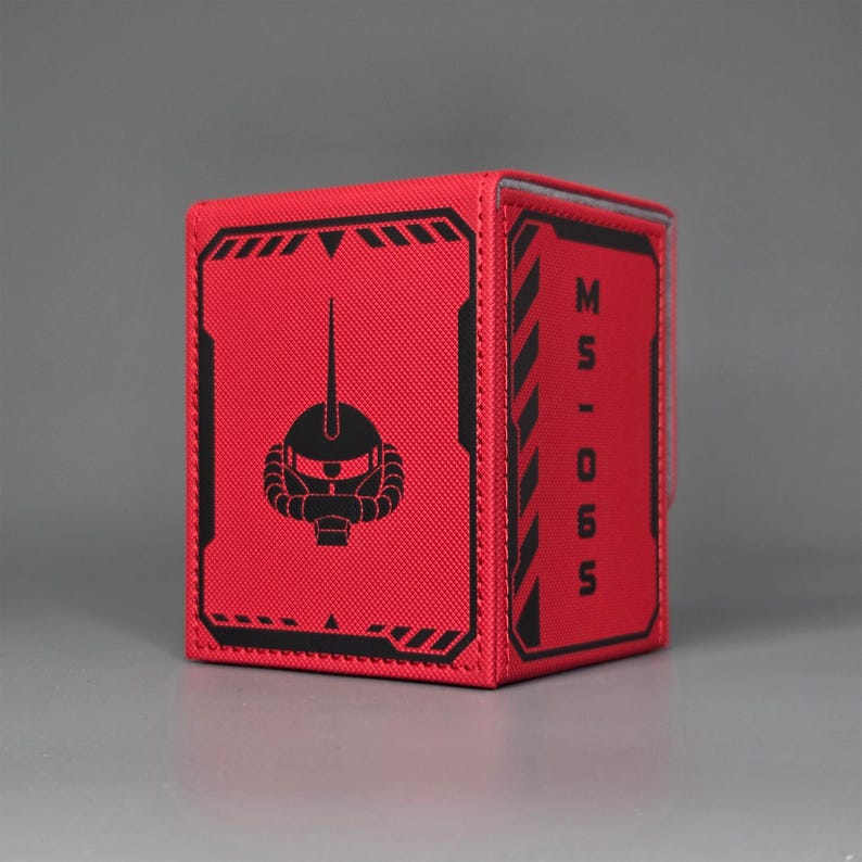 Red Gundam inspired trading card deck box shown at an angle with mobile suit head emblem and MS-06S text panel. Char's Zaku II