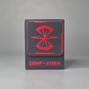Front view of black Gundam inspired deck box with large red faction emblem and ZGMF X09A marking on lower panel
