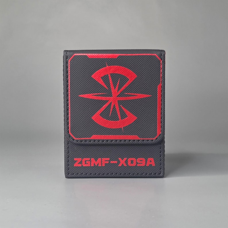 Front view of black Gundam inspired deck box with large red faction emblem and ZGMF X09A marking on lower panel