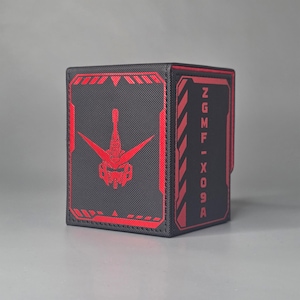 Black Gundam inspired trading card deck box shown at an angle with red mobile suit head emblem and ZGMF X09A text panel