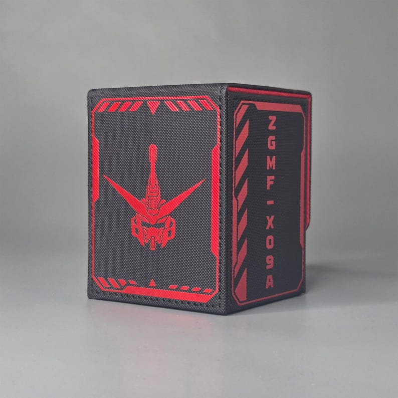 Black Gundam inspired trading card deck box shown at an angle with red mobile suit head emblem and ZGMF X09A text panel
