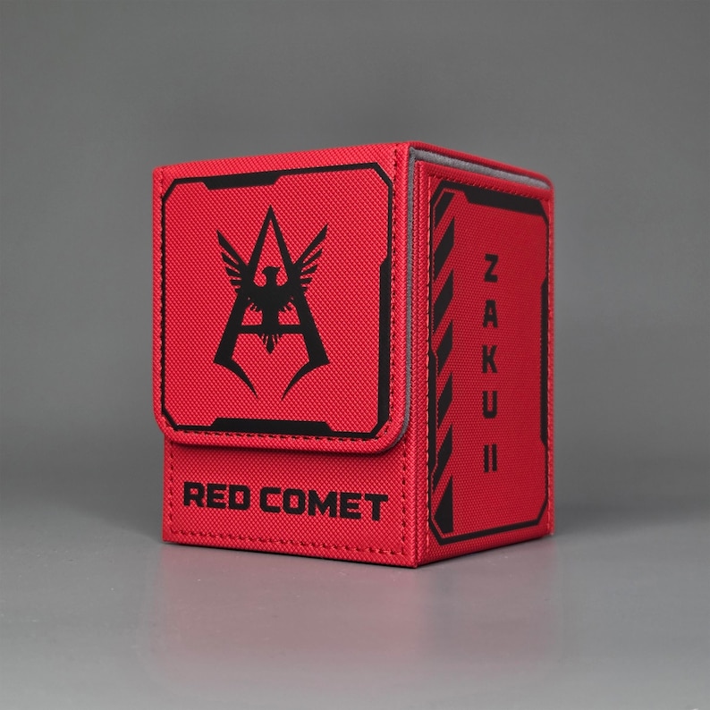 Angled Front view of red trading card deck box featuring Zaku II text panel and Red Comet text with faction style insignia design