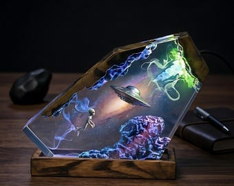 Lámpara de resina con forma de galaxia que representa a un astronauta soñando con ovnis y contacto extraterrestre. Un regalo único para los entusiastas del universo.