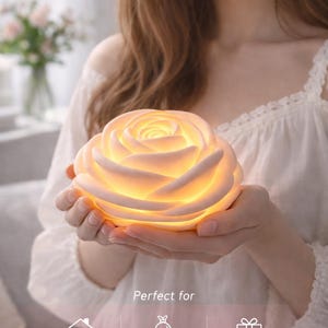 Puede incluir: Lámpara con forma de rosa que emite una luz cálida, sostenida en manos. El texto "BEAUTIFUL GLOW STUNNING DESIGN" es visible. Perfecta para la decoración del hogar, bodas y proyectos de regalos. Un diseño impresionante.