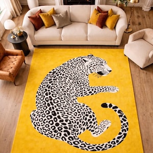 May include: A rectangular area rug featuring a vibrant yellow background with a large, centered illustration of a leopard. The leopard is depicted in a seated position, rendered in black and white with detailed spots covering its entire body.