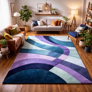Può includere: Un grande tappeto rettangolare con un design a onde nei toni del blu, viola e bianco. Il tappeto è posizionato su un pavimento in legno e aggiunge un tocco di colore al soggiorno. Il design crea un look moderno ed elegante.