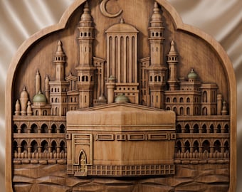 May include: A detailed wooden wall carving featuring a central cubic structure resembling the Kaaba, surrounded by an intricate architectural scene of minarets, arched colonnades, and domes, topped with a crescent moon symbol in a rounded frame.