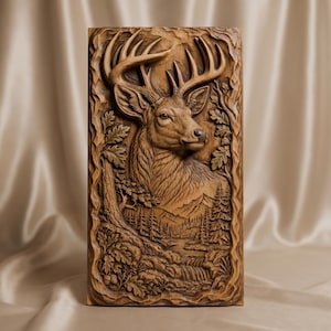 Può includere: Una placca da parete rettangolare in legno con un dettagliato intaglio in rilievo di una testa di cervo con grandi corna. La scena include un paesaggio boschivo con pini, montagne e un piccolo ruscello, incorniciato da foglie di quercia e rami.