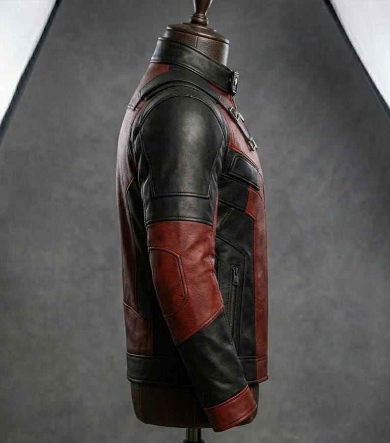 May include: A two-tone leather jacket in black and burgundy, displayed on a mannequin. The jacket features a stand-up collar, a zippered front, and paneling on the sleeves and torso. The jacket is a medium weight.