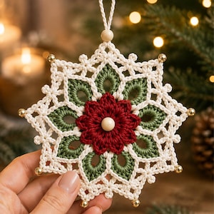 May include: A crocheted snowflake ornament featuring a central deep red flower with a light wooden bead at its core. The design includes olive green petal-like shapes surrounded by cream-colored yarn, accented with small gold beads at each point.