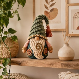 May include: A handcrafted crochet gnome figurine featuring a tall, spiraled olive green hat with a rust-colored tassel, a cream-colored beard with a central swirl, a round wooden nose, and a dark teal body accented with small orange spirals.