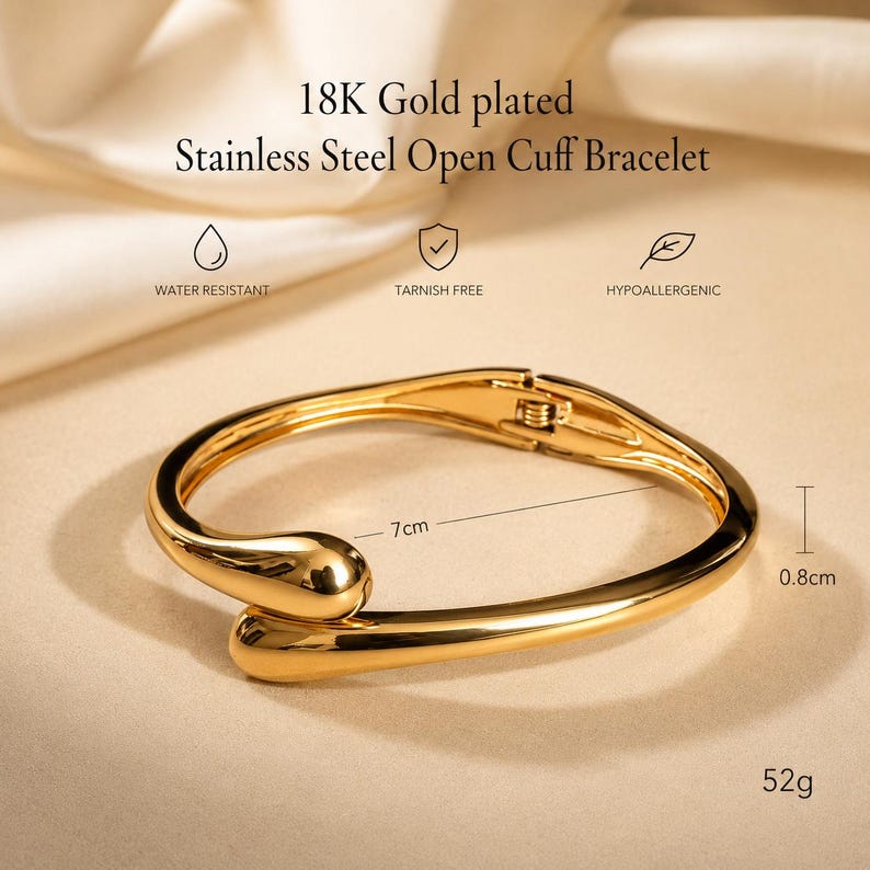 May include: An 18K gold plated stainless steel open cuff bracelet with a polished finish. The text reads 18K Gold plated Stainless Steel Open Cuff Bracelet, Water Resistant, Tarnish Free, Hypoallergenic. It measures 7cm by 0.8cm and weighs 52g.