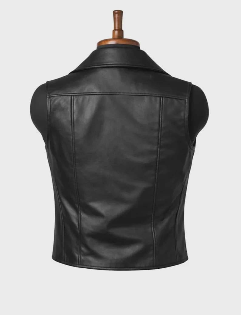 May include: A black leather vest displayed on a mannequin. The vest has a classic collar, a tailored fit, and vertical seams running down the front and back. The vest is a solid black color and appears to be made of smooth leather.