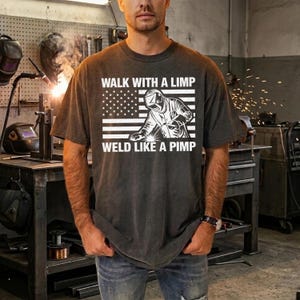 May include: A white ceramic mug with a black handle and the text "But First, Coffee" in a bold, black font. The mug is set against a blurred background, suggesting a cozy setting. The mug appears to be approximately 4 inches tall.