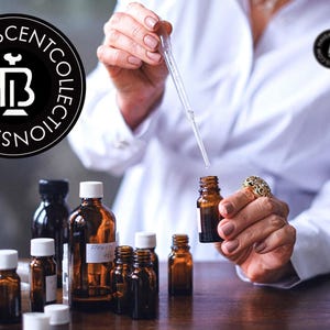May include: A collection of amber glass bottles and clear glass perfume bottles. A person in a white lab coat is using a pipette to dispense liquid into a small amber bottle. The image includes the logo for Haveascentcollections.com.