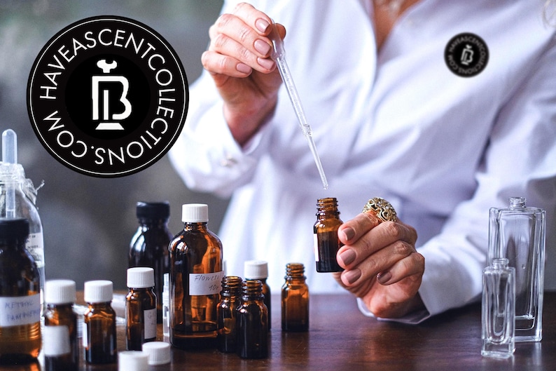 May include: A collection of amber glass bottles and clear glass perfume bottles. A person in a white lab coat is using a pipette to dispense liquid into a small amber bottle. The image includes the logo for Haveascentcollections.com.