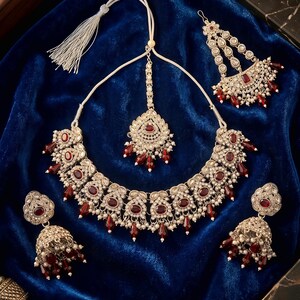 Ruby Kundan bruidssieraden set rode stenen choker ketting met Jhumka-oorbellen en Maang Tikka.
