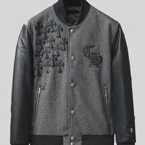 May include: A grey wool-blend varsity jacket with black leather sleeves. The front features black embroidered cross patches on the right side, a black embroidered CH logo on the left, silver-toned metal buttons, and two zippered side pockets.
