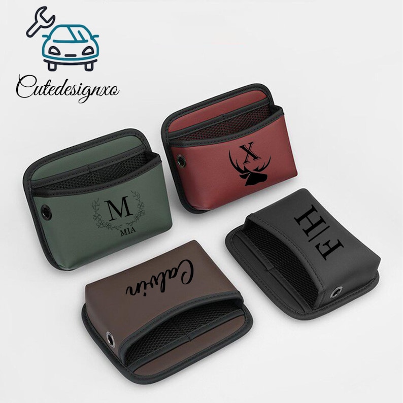 May include: Four personalized car organizers in various colors: green, burgundy, brown, and black. Each organizer features a mesh pocket and custom text or a deer head design. The organizers are designed to hold small items.