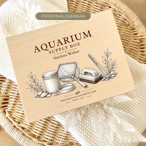 Könnte beinhalten: Eine rechteckige, helle Holzbox mit einer dunkelbraunen Gravur von Aquarienzubehör wie einem Netz, einem Behälter, einem Schaber und Wasserpflanzen. Der Text lautet "AQUARIUM SUPPLY BOX", "Markus Weber" sowie "PROFESSIONAL AQUARIUM CARE SINCE 1914".