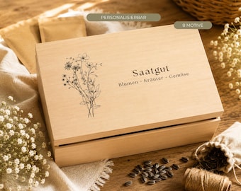 Può includere: Una scatola rettangolare in legno chiaro con coperchio incernierato, caratterizzata da un disegno a linee nere di un bouquet di fiori di campo e dal testo "Saatgut Blumen · Kräuter · Gemüse". La scatola è progettata per conservare i semi.