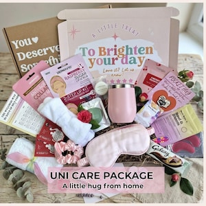 May include: A gift box containing a pink tumbler, a light pink sleep mask, a white headband, a pink scrunchie, a Raspberry Sugar Lip Scrub kit, a Galaxy chocolate bar, and various skincare packets. The box lid reads A Little Treat To Brighten your day.