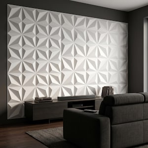Puede incluir: Un panel de pared 3D blanco y geométrico con un patrón de estrella repetitivo. El panel es el punto focal de una sala de estar moderna, complementado por un mueble de entretenimiento de madera oscura y un sofá gris oscuro. También se ven libros y una barra de sonido.