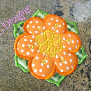 May include: A bright orange flower with white polka dots and a yellow center. The flower is surrounded by green leaves and has a decorative orange border.