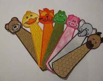 May include: Set of eight colorful embroidered fabric bookmarks featuring animal faces, including a bear, duck, cat, frog, pig, elephant, and a horse.