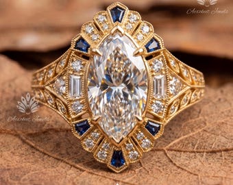 May include: A gold ring featuring a large marquise-cut centre stone surrounded by a halo of smaller round diamonds, baguette-cut diamonds, and deep blue trapezoid-shaped sapphires, all set within an intricate, filigree-detailed gold band.