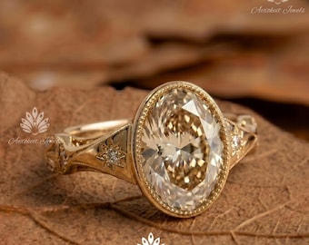 May include: A gold ring featuring a large oval-cut champagne-coloured centre stone set in a milgrain bezel. The band is crafted with intricate metalwork, including star-shaped accents on each side, each containing a small embedded round diamond.