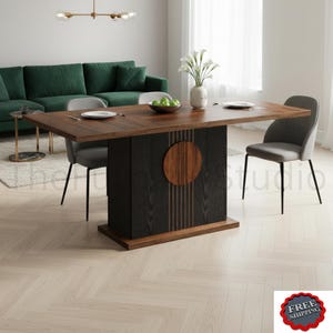May include: A rectangular dining table with a dark brown wood grain top and a black pedestal base featuring vertical slats and a circular wood accent. The table is accompanied by two gray upholstered chairs with black metal legs.