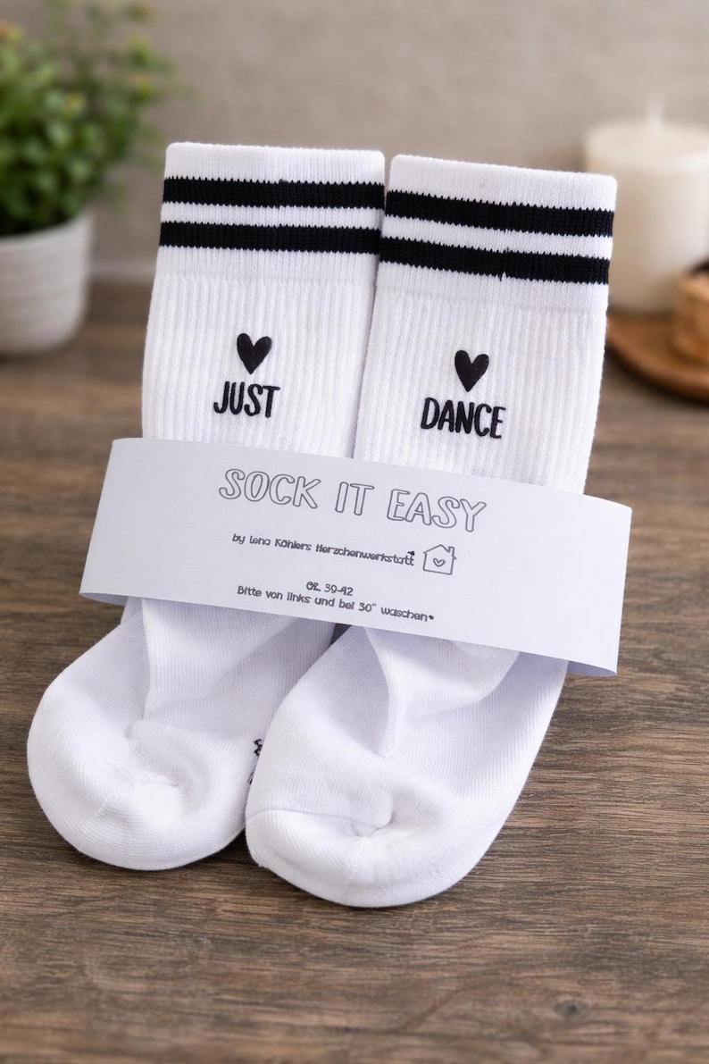 Pu&ograve; includere: Calzini bianchi con strisce nere e le parole "JUST" e "DANCE" con cuori. La confezione dice "SOCK IT EASY". Taglia 39-42.