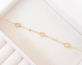 Delicada pulsera con dije de cometa con rombos y circonita cúbica en oro de 14k