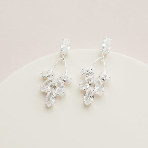 May include: Silver dangle earrings with a cluster of clear marquise-shaped crystals.