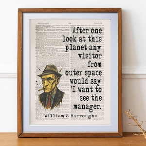 May include: Framed art print featuring a portrait of a man with a hat and a quote: "After one look at this planet any visitor from outer space would say 'I want to see the manager.'" The print is on a vintage book page.