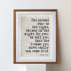 Puede incluir: Impresión enmarcada con una cita de Peter Pan en una página de libro antiguo. El texto negro dice: "La segunda estrella a la derecha, brilla en la noche para ti, para decirte que los sueños que tienes realmente pueden hacerse realidad."
