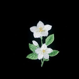 May include: Embroidered floral patch featuring two white flowers with yellow centers and green leaves. The patch is set against a black background, highlighting the delicate details of the needlework. Ideal for fabric embellishment.