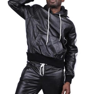 May include: Black leather hoodie and matching pants with white stripes. The hoodie has a drawstring hood and a front pocket. The pants have a drawstring waist. The outfit is made of a shiny leather material.