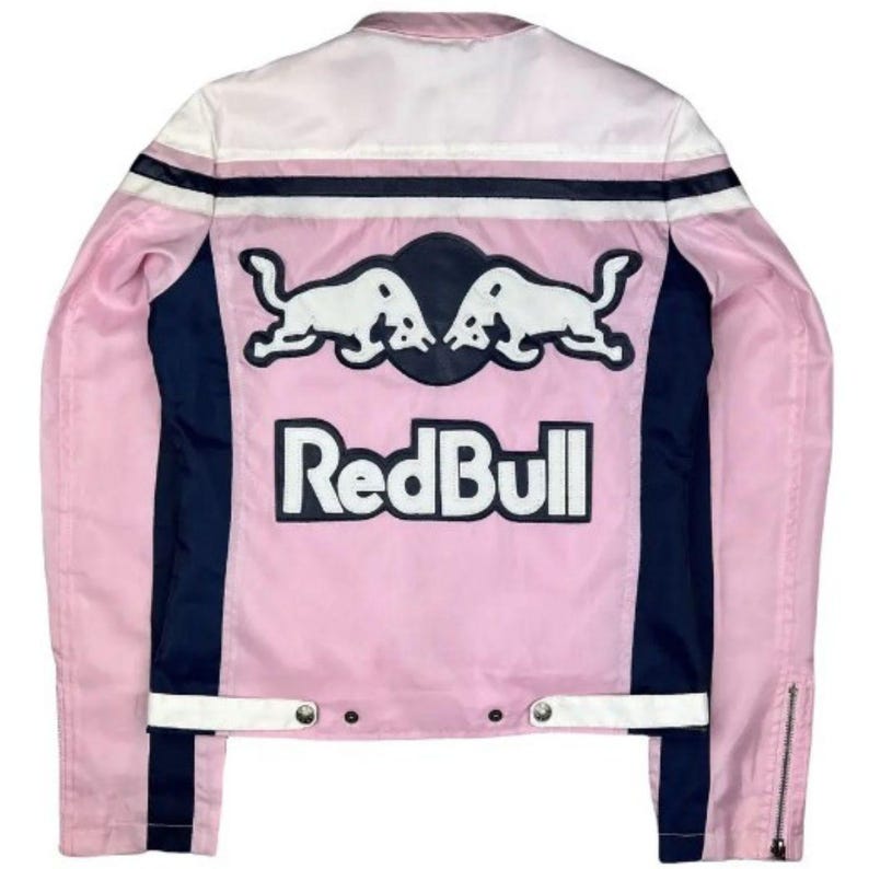 May include: Pink and white jacket with black and white accents. The back features the Red Bull logo with two white bulls and the brand name in bold white letters. The jacket has a zipper closure and a classic racing style.