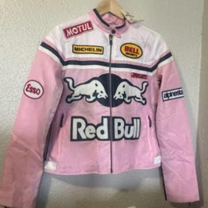May include: Pink and white motorcycle jacket with multiple patches, including "MOTUL", "MICHELIN", "BELL HELMETS", and "Esso". The jacket features a "Red Bull" logo and a "Ducati" emblem. The jacket has a zipper closure and a collar.