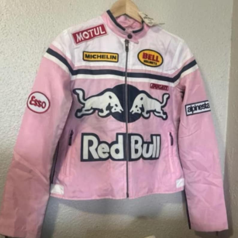 May include: Pink and white motorcycle jacket with multiple patches, including "MOTUL", "MICHELIN", "BELL HELMETS", and "Esso". The jacket features a "Red Bull" logo and a "Ducati" emblem. The jacket has a zipper closure and a collar.