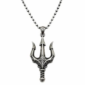 May include: A silver-toned metal pendant shaped like a trident with intricate engraved detailing, suspended from a matching silver-toned ball chain necklace. The trident features a central spear point flanked by two curved prongs and a rope-textured handle.