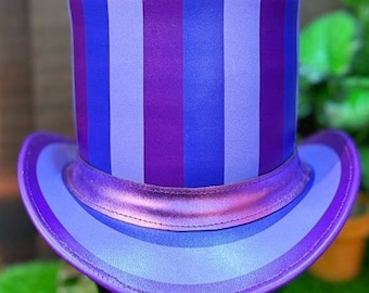 Peut inclure: Un haut-de-forme violet avec des rayures verticales bleues et lavande. Il présente un large bord et une bande violette métallique autour de la couronne. Un accessoire unique pour les événements.