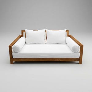May include: A modern wooden daybed with a white mattress, two square pillows, and two cylindrical bolster pillows. The frame is made of light brown wood. The daybed is designed for relaxation and lounging.