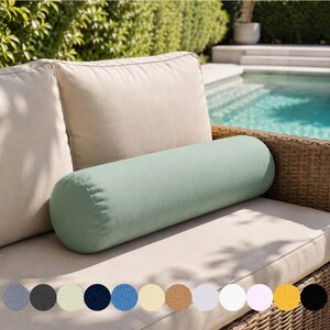 May include: A light green cylindrical bolster pillow rests on a beige outdoor sofa with a woven wicker frame. The pillow is surrounded by beige cushions. A selection of fabric swatches in various colors are displayed below the sofa.
