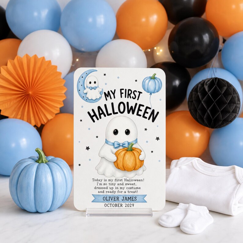 Baby’s first Halloween announcement mockup featuring a white ghost holding a pumpkin, a ghost on a blue crescent moon, a blue pumpkin balloon, baby clothing, and blue, orange, black, and white decorations.