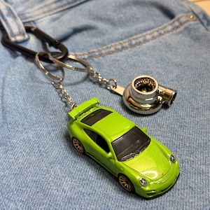 Puede incluir: Una taza de cerámica blanca con un asa negra y el texto "But First, Coffee" en negro, en negrita. La taza está sobre una superficie blanca.